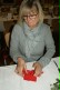 Eine Lehrerin bereitet die Dekoration vor. Sie faltet aus roten Servietten Nikolausstiefel.